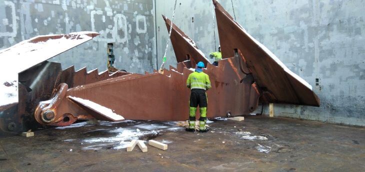 Workers preparing huge anchors for transport