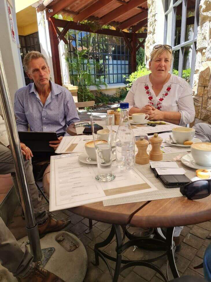 A group of people at a table are drinking coffee