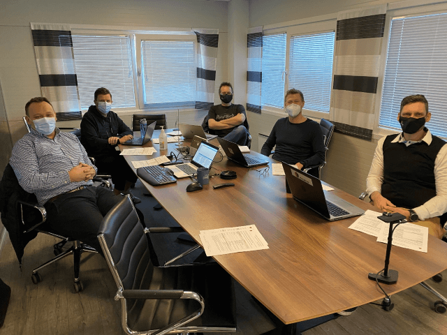 Men are sitting at the table in the conference room