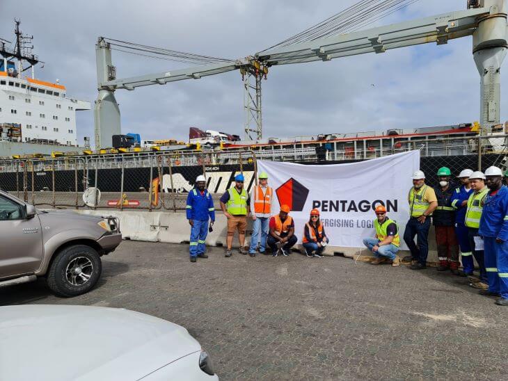 Workers in helmets on the background of a Pentagon company image banner