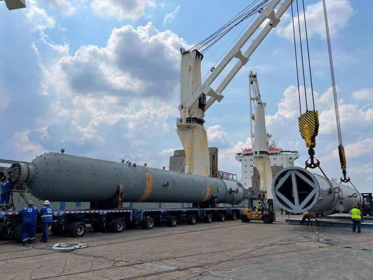 Crane positioning a refinery towers to a transport