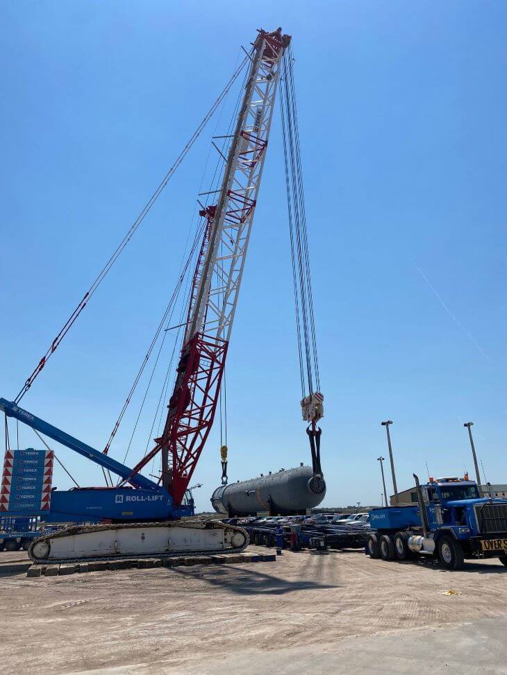 Crane positioning a refinery tower on a truck