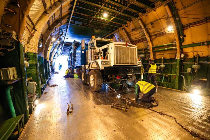 A heavy equipment truck driving onto the transport plane