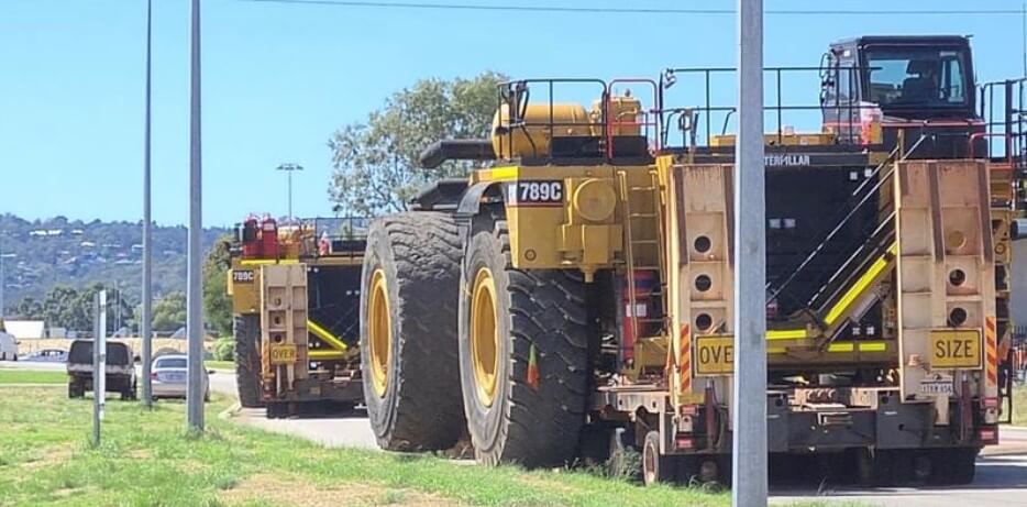 Two giant dump trucks on the street