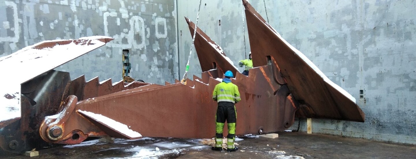 Workers preparing huge anchors for transport