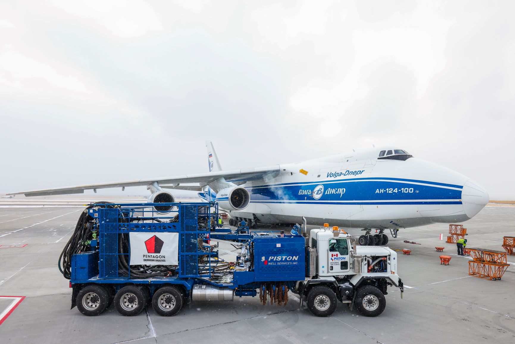 A truck with heavy equipment on the background of an airplane