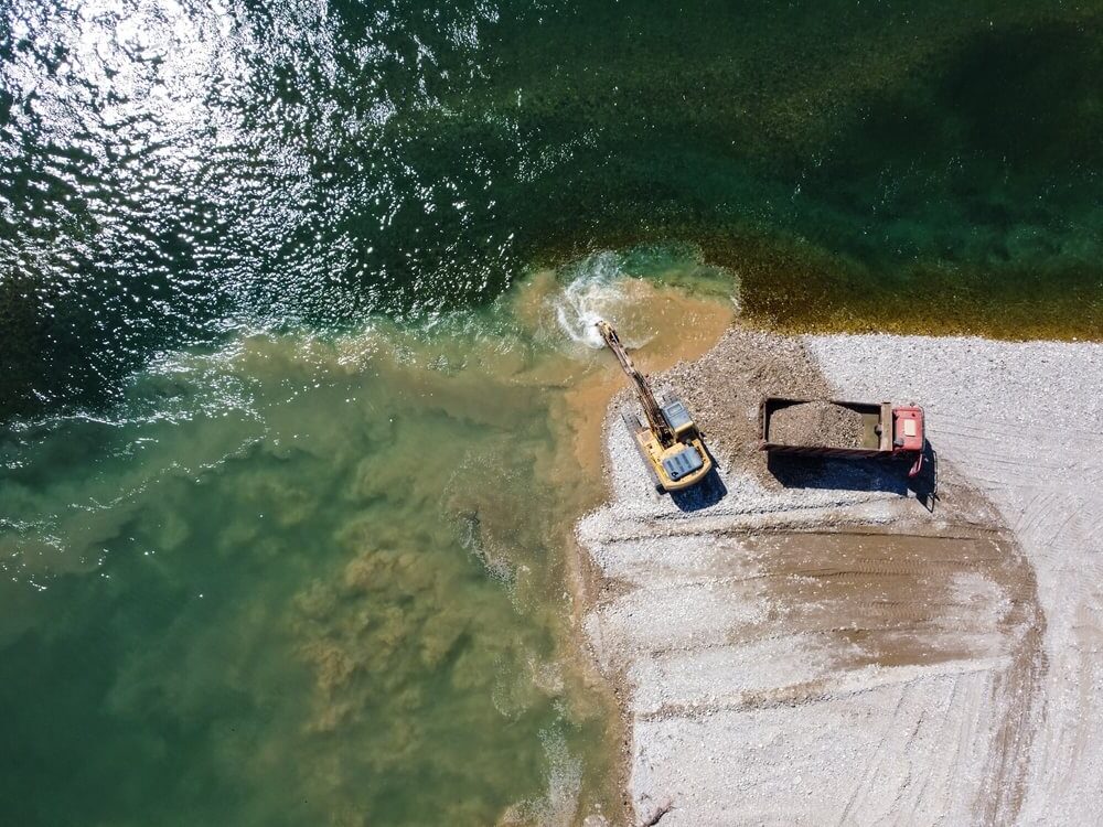 An excavator extracting gravel from the water