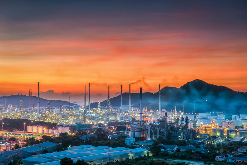 A huge refinery in the mountains at sunset