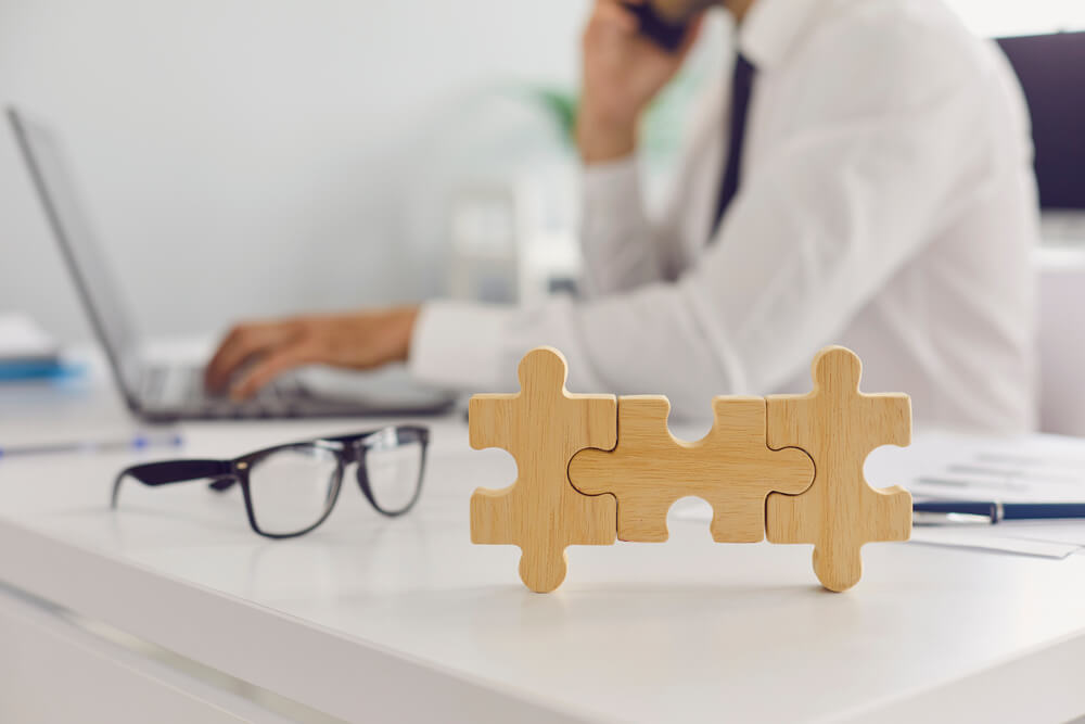 Wooden puzzles and eyeglasses on the desk of the worker