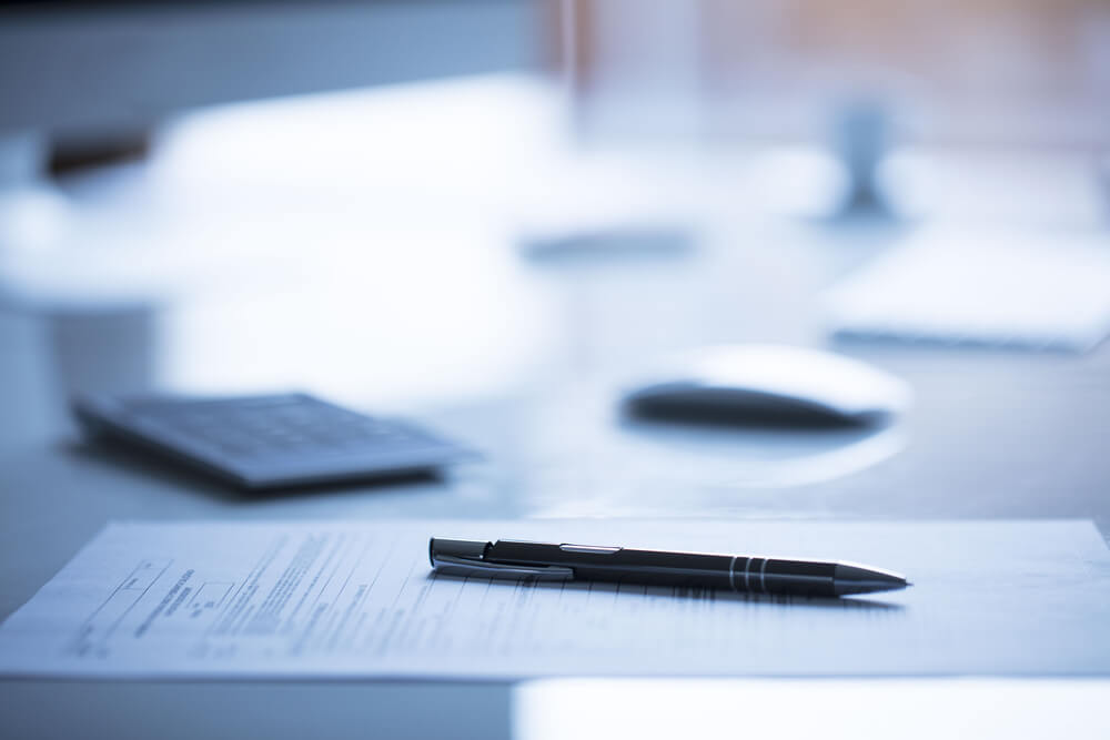 A pen and documents on the desk