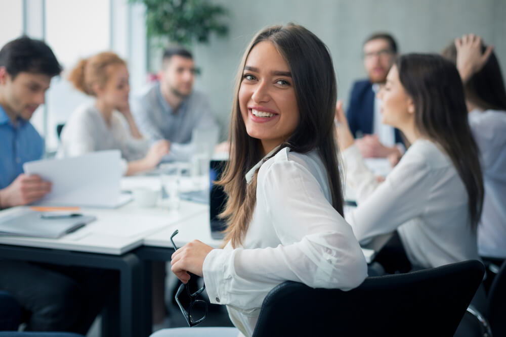 Smiling woman at a business meeting with a team